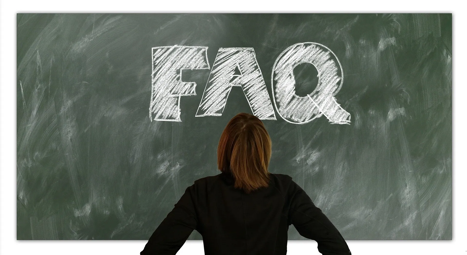 A student reviews a chalkboard marked FAQ