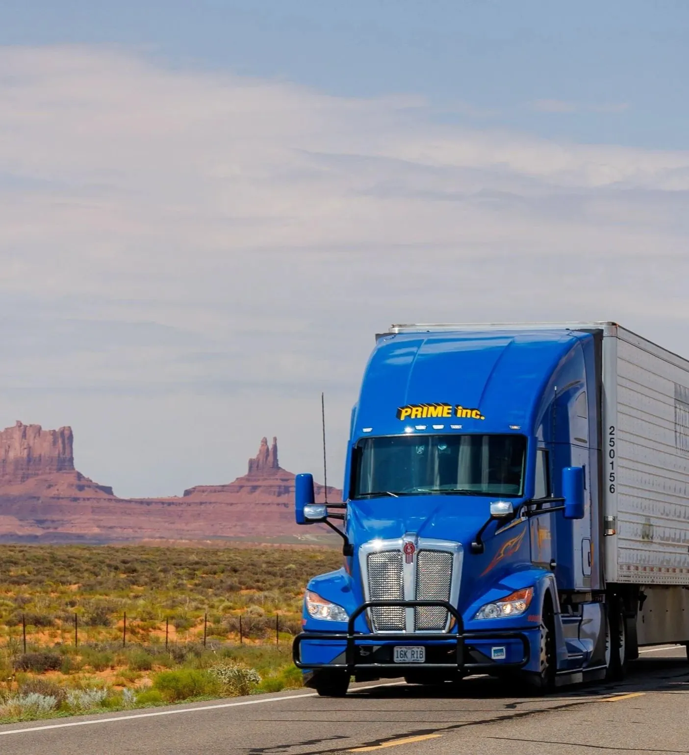 A blue semi-truck on an open highway